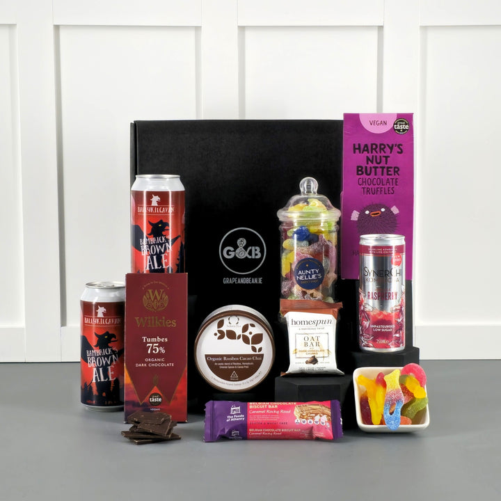 Assorted snacks and drinks including cans beer, chocolate, jellies, chocolate, tea bags, truffles in a black gift box