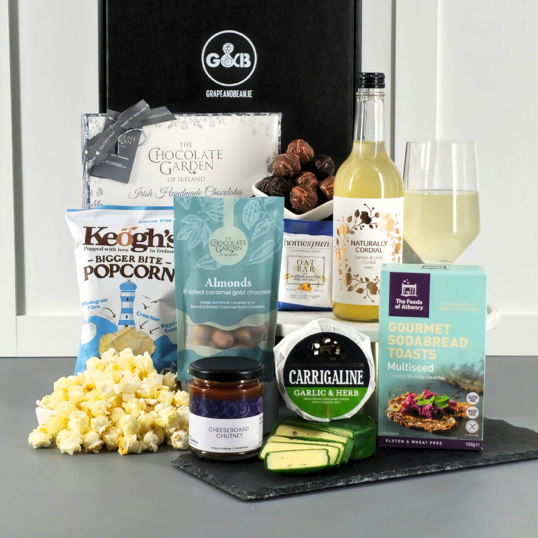 Black gift box with cordial, cheese, chutney, chocolate, popcorn, cordial.