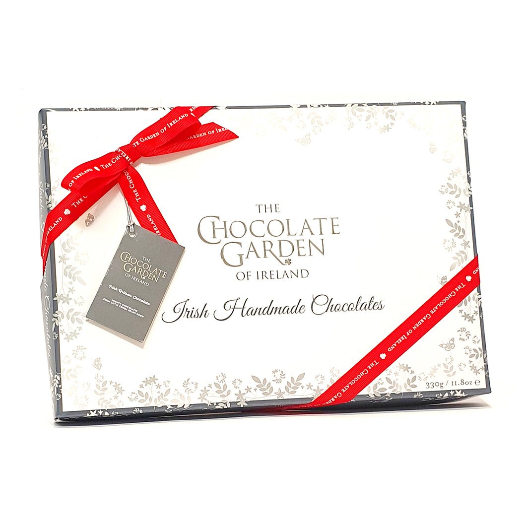 Gift box of Irish handmade chocolates from The Chocolate Garden of Ireland with a red ribbon.