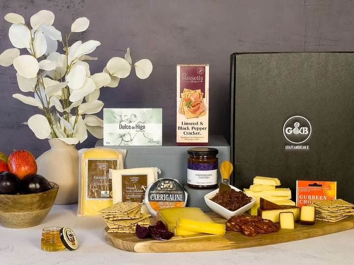 Assorted gourmet food items including cheese, crackers, chorizo, fig paste, chutney