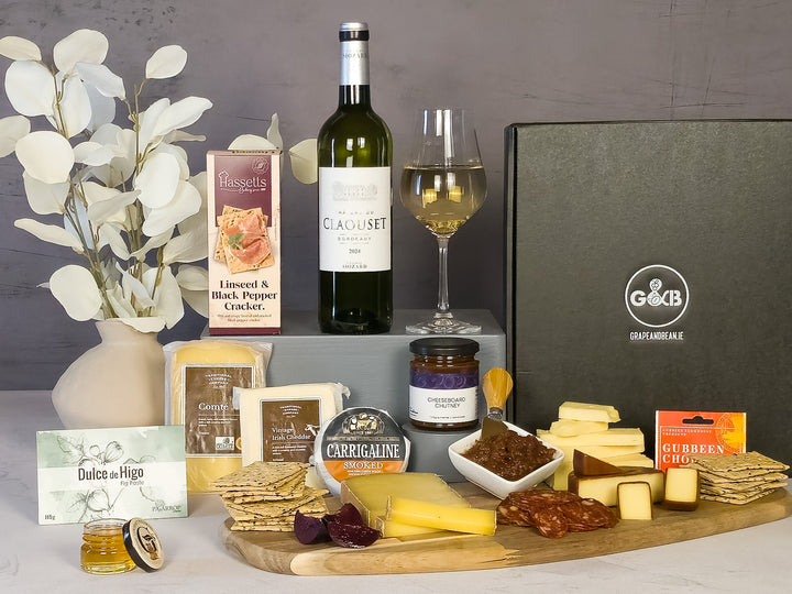 Gourmet food of  cheese, crackers, white wine, chutney, chorizo, fig paste in a black gift box