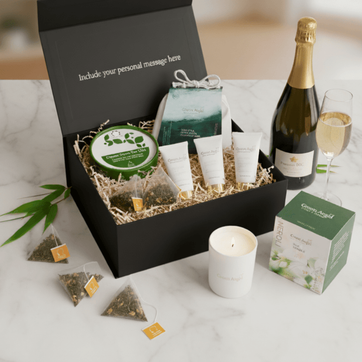 Gift box with skincare products, champagne, and tea on a marble surface